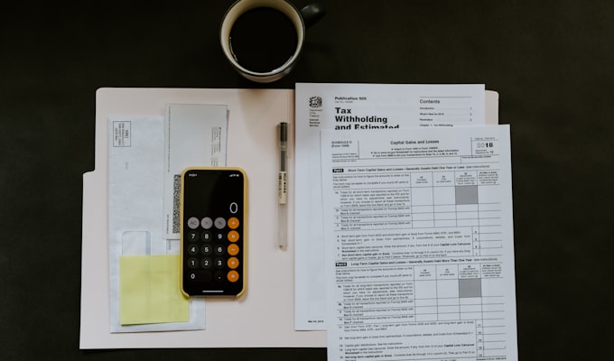 Accountant filing GST returns on a laptop with invoices on the table