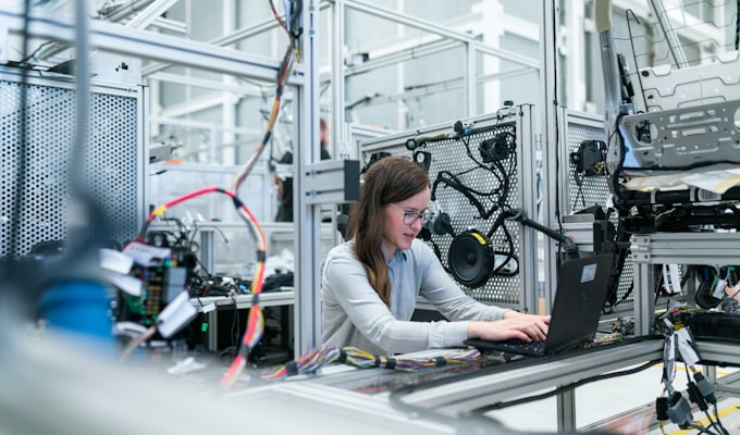 Engineer reading machine performance data on a tablet next to a CNC